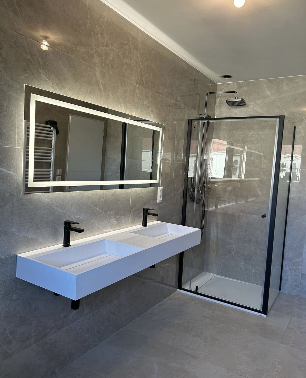 Installation douche à l'italienne avec carrelage grand format effet marbre sols et murs pose double vasque moderne miroir eclaire paroie de douche noires renovation salle de bain Nice